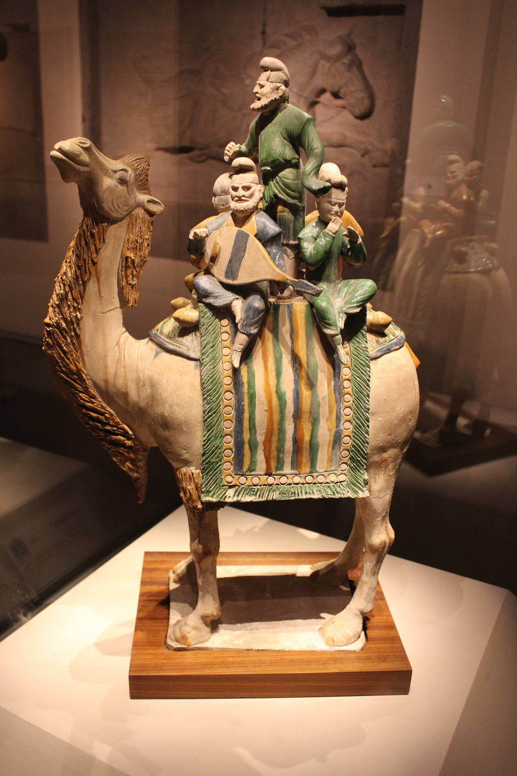骑驼乐舞三彩俑三彩釉陶骆驼载乐俑,也称为骑驼乐舞三彩俑,唐代明器
