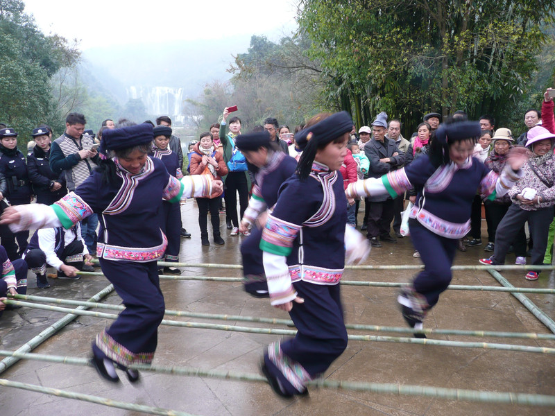 布依族的美女们随着轻快的节奏挑起竹竿舞