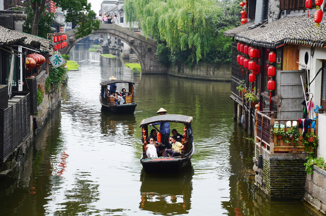 游客乘坐游船,享受江南水乡古镇的春天.