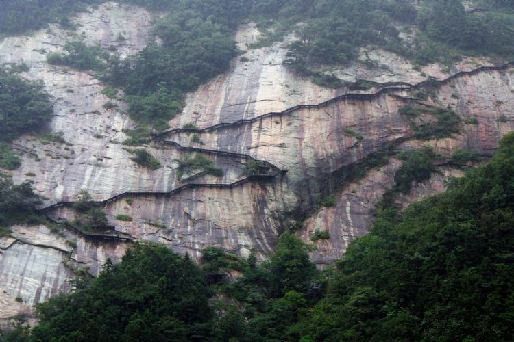 对面山便是白马峰,"之"字形木栈道从山腰往上,用钢架搭建在千米绝壁上