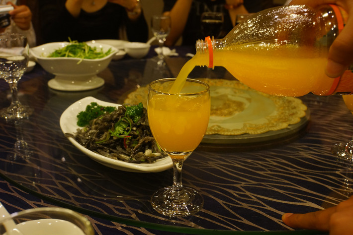 倒满清凉饮料的酒杯沿着餐桌转动,流转