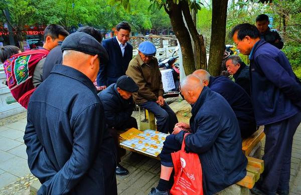 八一公园里最多的是老人们,老头们基本都成堆的在下棋或打牌,围观者