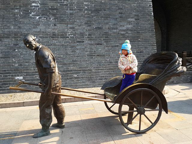 一座铜铸的拉车人,再现当年景.